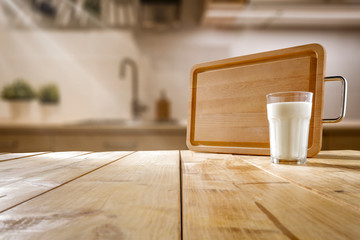 Fototapeta na wymiar Fresh cold milk on wooden table and kitchen interior.Spring sunny day and free space for your decoration. 