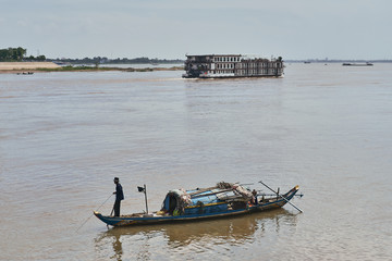 fisherman and boat in the mekong river in phnom penh