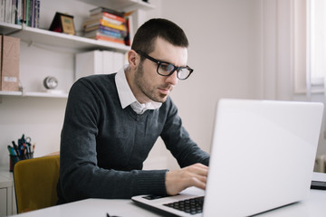 Bearded young businessman working at office with laptop