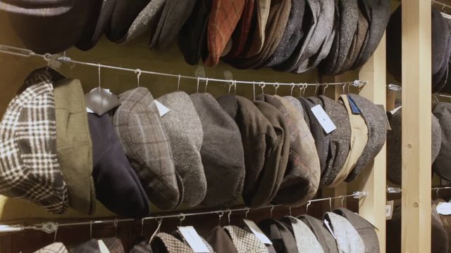 Large assortment of flat caps hanging on showcase in clothes shop