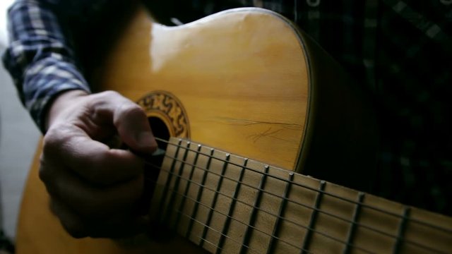 Male musicians playing acoustic guitar. Closeup musicians are playing acoustic guitar. Male musicians hold chords and strum guitar. Retro, music, lifestyle concepts.