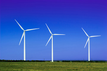 A group of wind turbines with blue sky background