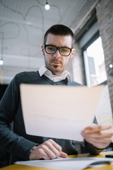 Male lecturer standing in the office and reading
