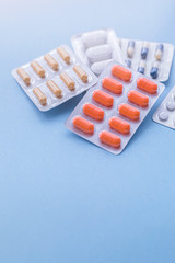 Tablets and pills on blue background, medicine drugs concept, toned