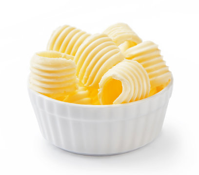 Butter curls or butter rolls in white bowl isolated on white background.
