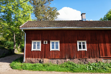 Fototapeta na wymiar View of traditional red wooden cottage in Turku, Finland. This rural area has been inhabited since the 7th century.