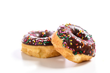 Chocolate glazed donuts with sprinkles on a white background