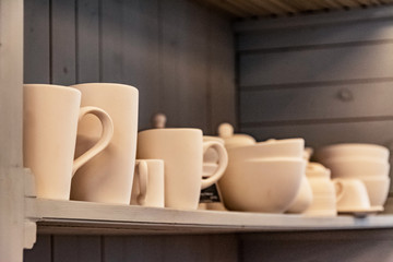 a set of ceramic products made of unburned clay standing on a shelf