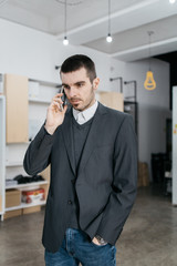 Serious man with elegant jacket talking on phone