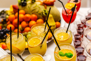 Citrus cocktail with slice of orange and green sweet. Cocktail and fruit on a table. Top view