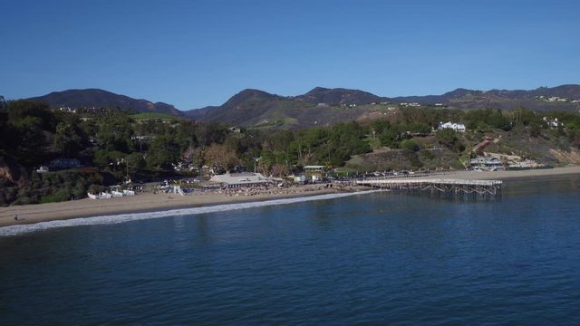 Panning aerial, people in Paradise Cove