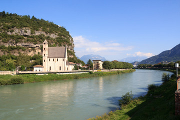 River Adige, church Sant Apollinare and mountain alps panorama in Trento, Italy