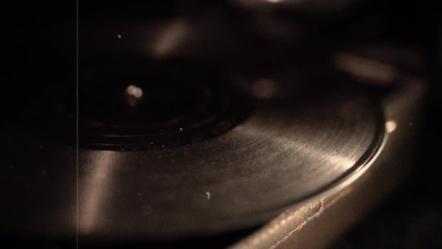 atmospheric vintage music device. gramophone needle on a rotating playing disc. old style vinyl disk player. Video footage. Edited stylized with scratches. Old film look imitation