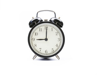 Black vintage alarm clock on a white background shows nine o'clock