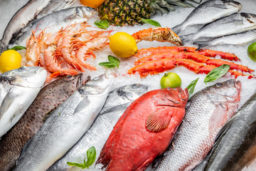 Fish, crab legs, lime, lemon and pineapple on a frappe ice