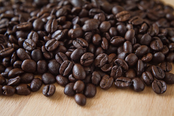 Freshly roasted coffee beans in the grinder on the wooden rustic board.