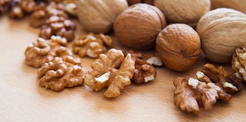 Fresh healthy walnuts nuts seeds on the wooden rustic board. Close up of the the open halves.