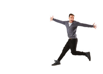 Excited young man jumping and smiling isolated