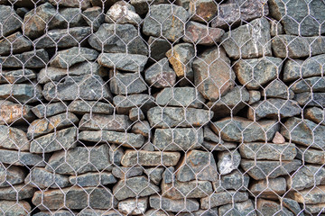 Mesh and stone fence, close-up of gabion for use in civil engineering, road building landscaping.