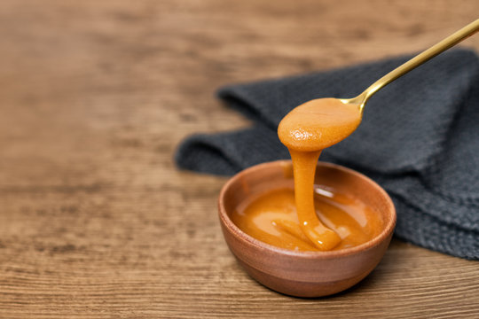 Manuka honey dipper dipping in raw organic liquid from Manuka flowers in New Zealand .Bees harvesting exclusively from this healthy antibacterial antifungal property flower.