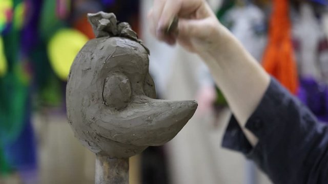 The artist, a master ceramist, sculpts the clay head of a doll for a puppet theater. Concept art with your own hands.