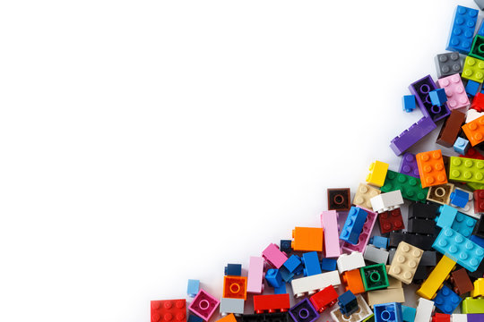 Close-up of a cluttered pile of colorful Lego bricks viewed from above with place for content or text. Isolated on white background, top view. Copy space.