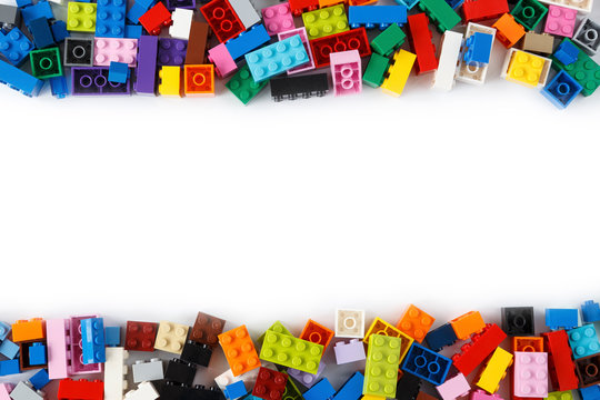 Tampere, Finland - February 21, 2020: Close-up of a cluttered pile of colorful Lego bricks viewed from above with place for content or text in the middle. Isolated on white background. Copy space.