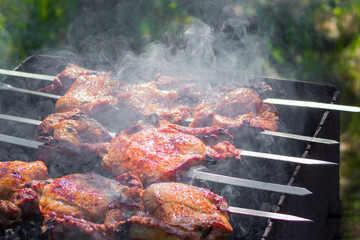 meat is fried on skewers on charcoal