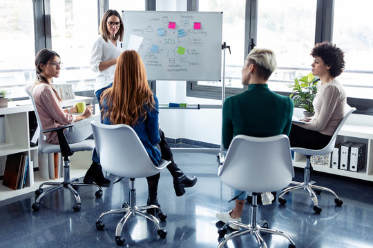 Businesswomen during meeting at a flipchart, presenting ideas for a search engine optimisation