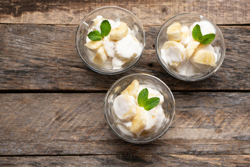 Banana with sour cream on wooden background