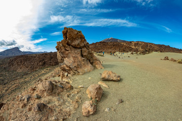 Mountain Teide with white snow spots, partly covered by the clouds. Bright blue sky. Teide National...