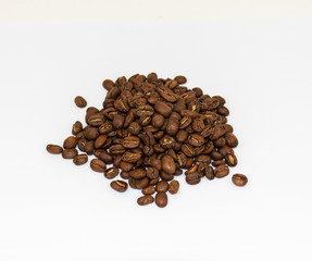 Small pile of coffee beans with a white backdropp