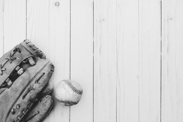 vintage baseball with glove on wooden background in black and white, copy space for sport