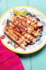 Mexican jicama and cucumber cutted with chili powder on turquoise background