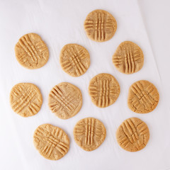Peanut butter cookies on parchment paper, isolated on background from top view.
