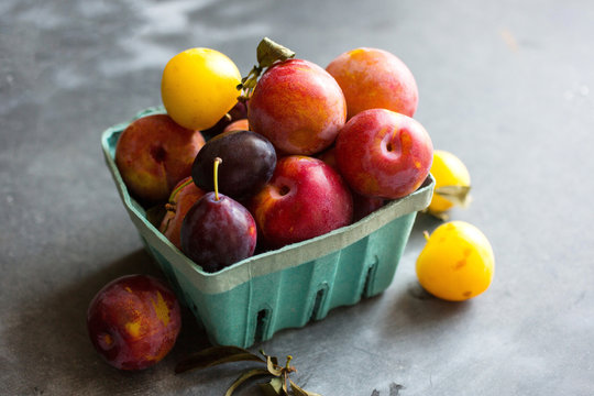 Basket full of red and yellow plums
