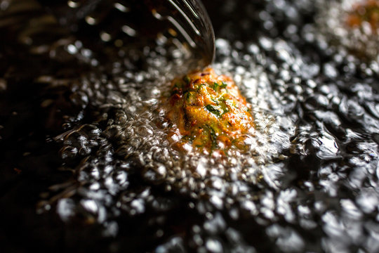 Squash dumplings being fried in oil