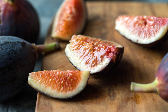 Selective focus of sliced fig on wooden board