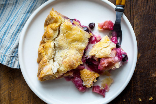 Piece of rhubarb blueberry pie served in plate