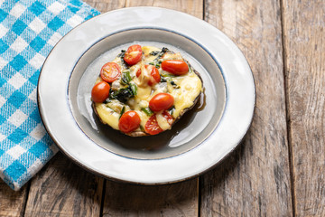 Portobello stuffed with spinach and cheese on wooden background