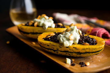 Selective focus of beluga lentil stuffed delicata squash on tray
