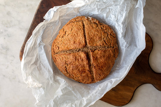 Whole wheat boule placed on wooden board