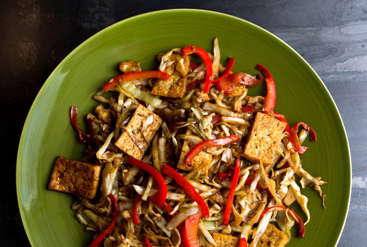 Close up of stir fried cabbage, tofu and red bell pepper served on plate