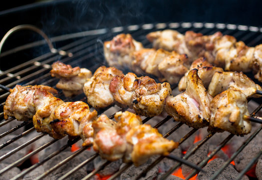 Close up view of barbecued chicken skewers