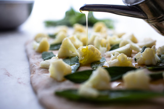 Selective focus of focaccia pizza making with cauliflower and sage