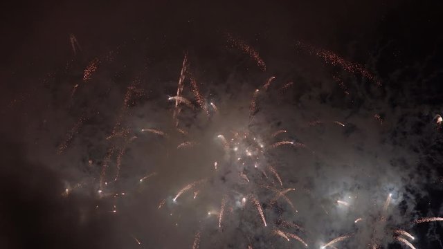 Multicolored fireworks display with exploding rockets in fumes and clouds of polluted air filled with metal particles and toxins.