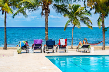 Tourists relaxing by tropical pool and beach