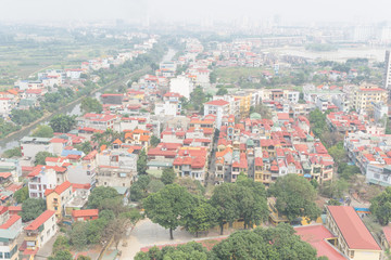 Aerial view residential houses and high-rise condominium building in foggy background