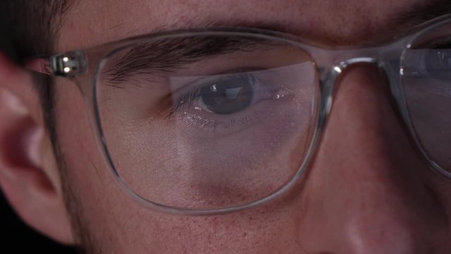 Computer coding reflection on the specs of a developer, closeup