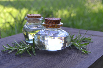 a bottle of rosemary aromatherapy oil, rosemary oil jar glass bottle and branches of rosemary